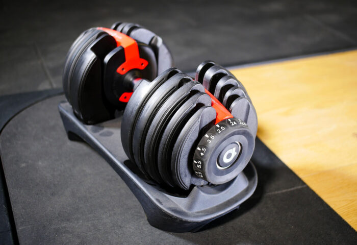 adjustable dumbbell 24kg against wood and rubber background