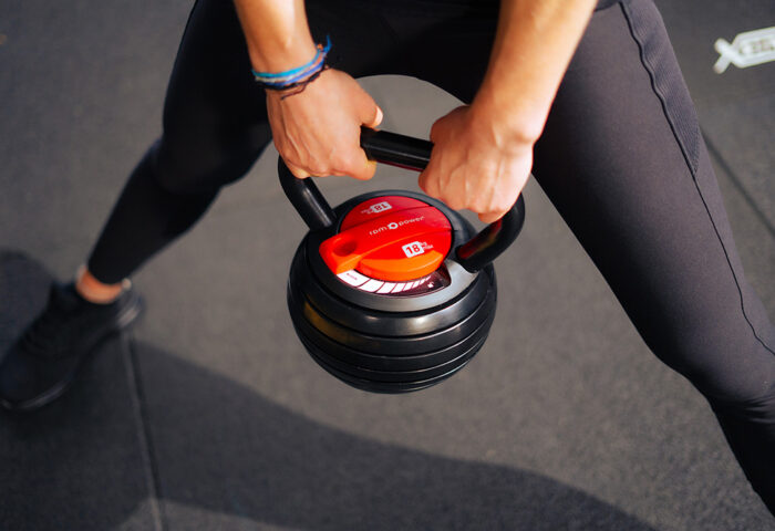 A person holding the 18kg adjustable kettlebell